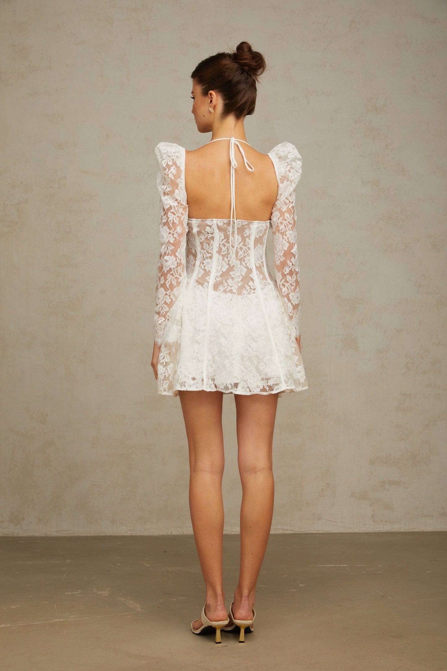 A white floral lace mini dress with a corset style bodice featuring a sweetheart neckline and short skirt