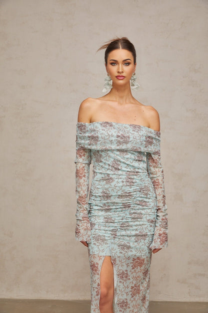 A long blue maxi dress with a floral print pattern and ruched details