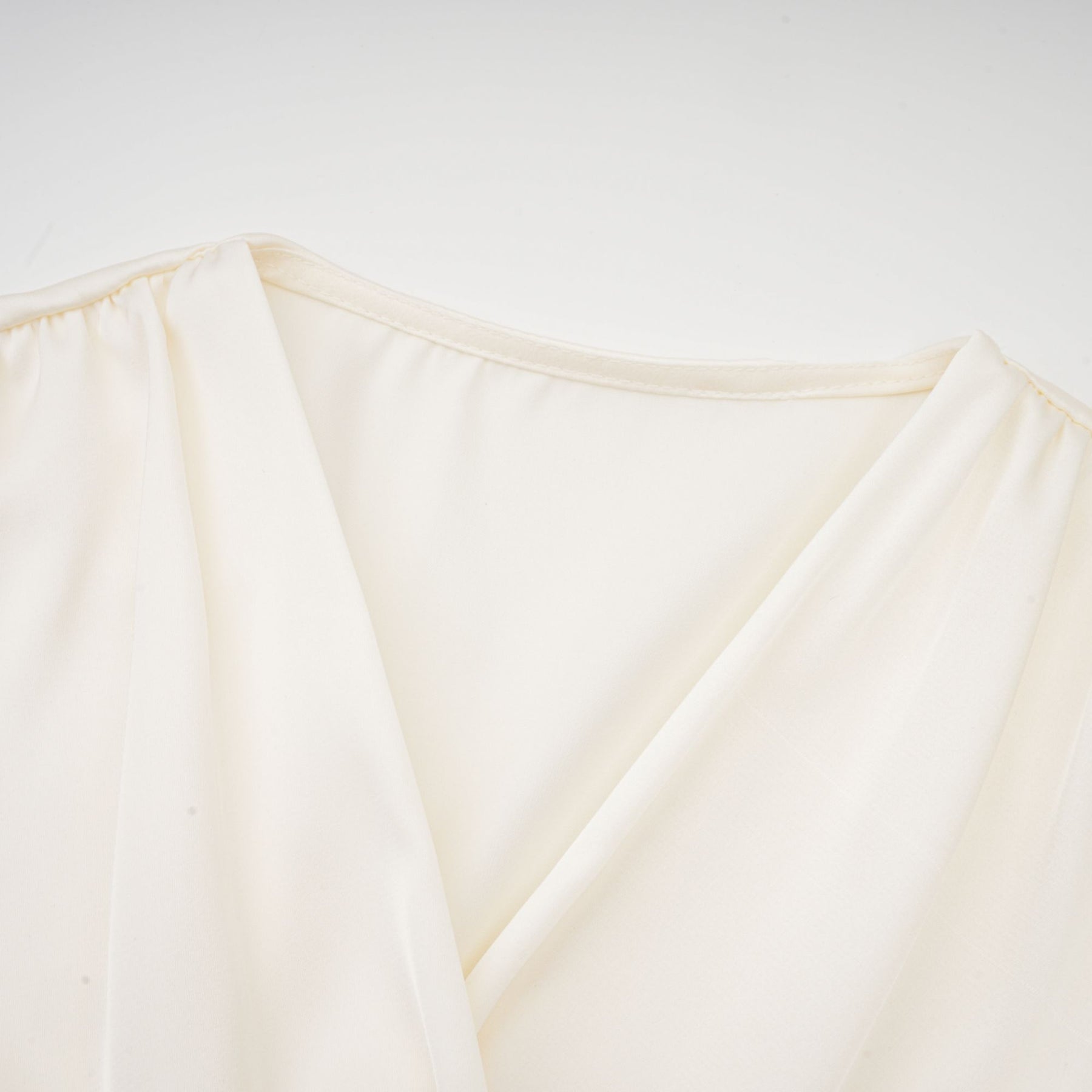 Kurzes weisses Oberteil mit gedrehtem Muster und dekorativen Kunstblumen