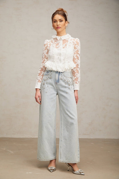 A white blouse with delicate floral embroidery and lace detailing named Karine