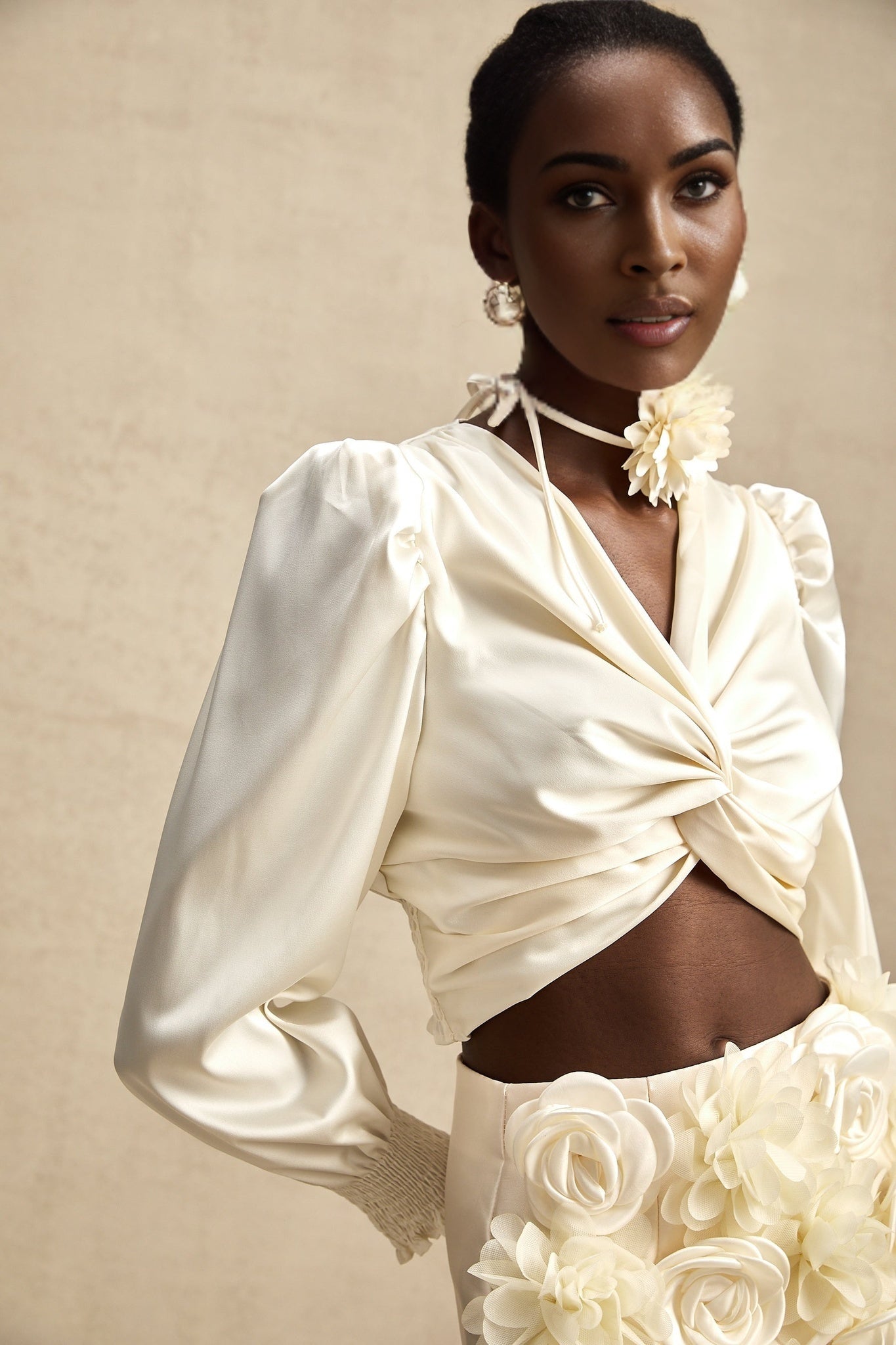 Short white top with twist pattern and artificial flowers named Nouria