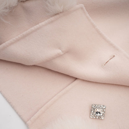 A pink short coat with a diagonal placket closure worn by a model standing against a plain background