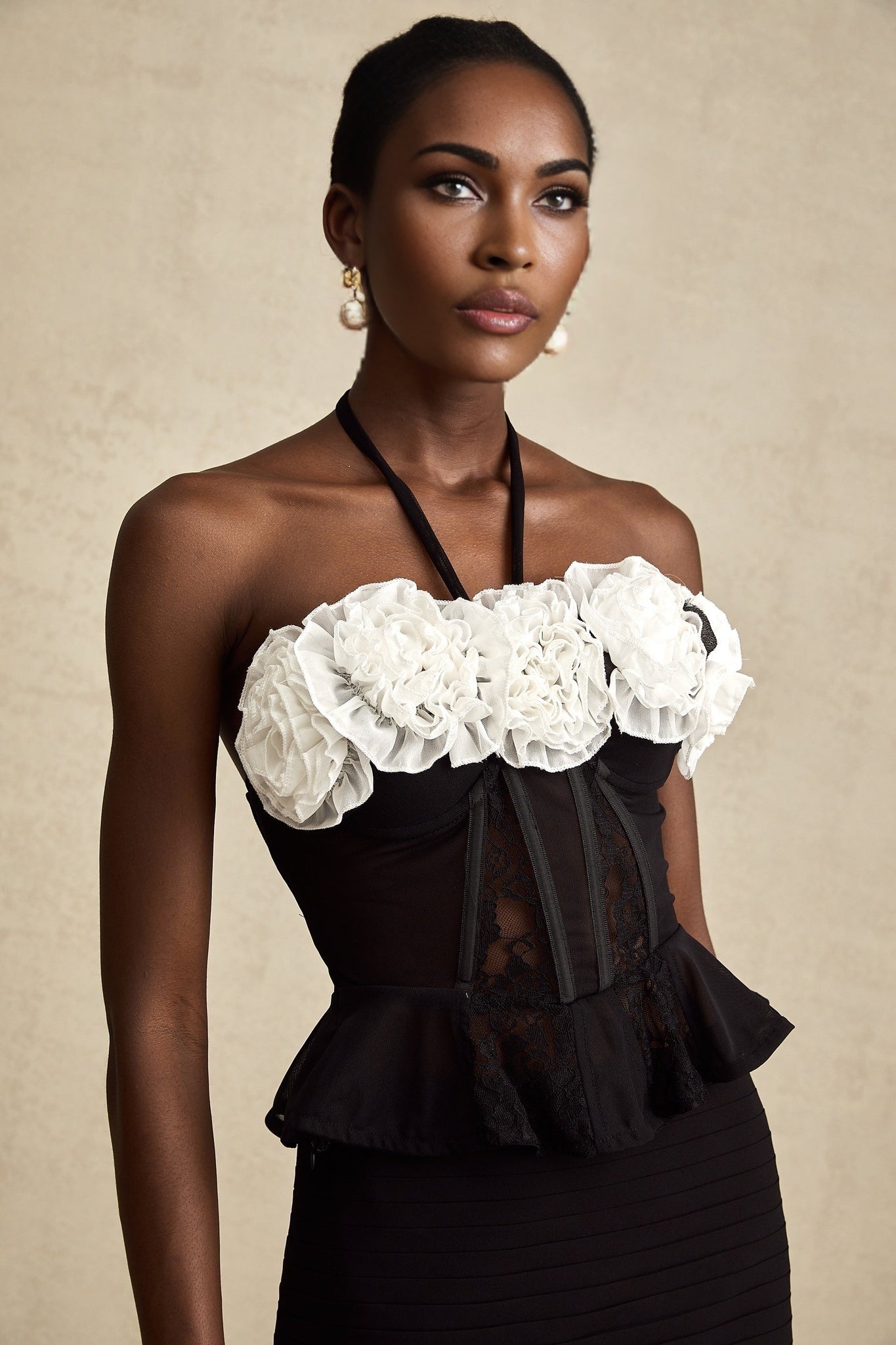 A black corset top with intricate faux flower lace design and boning details featuring a sweetheart neckline and adjustable straps