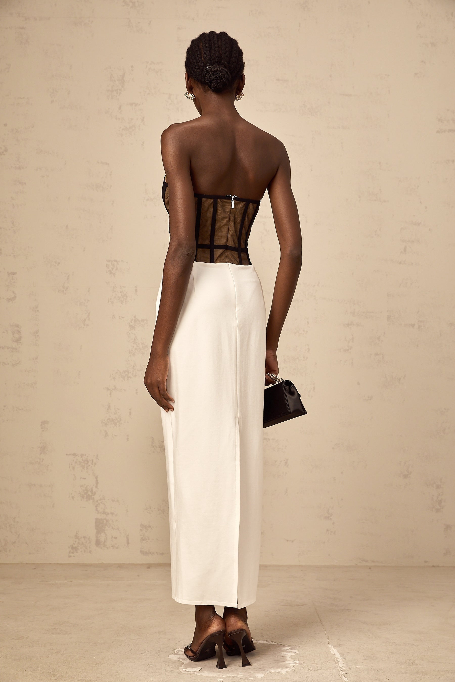 A long sheer maxi dress with a corsetstyle bodice featuring contrasting colors and a flowing skirt