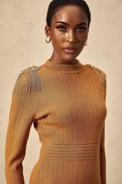 A woman wearing a ribbed knit midi dress with epaulet details on the shoulders The dress has a fitted silhouette and falls to mid calf length