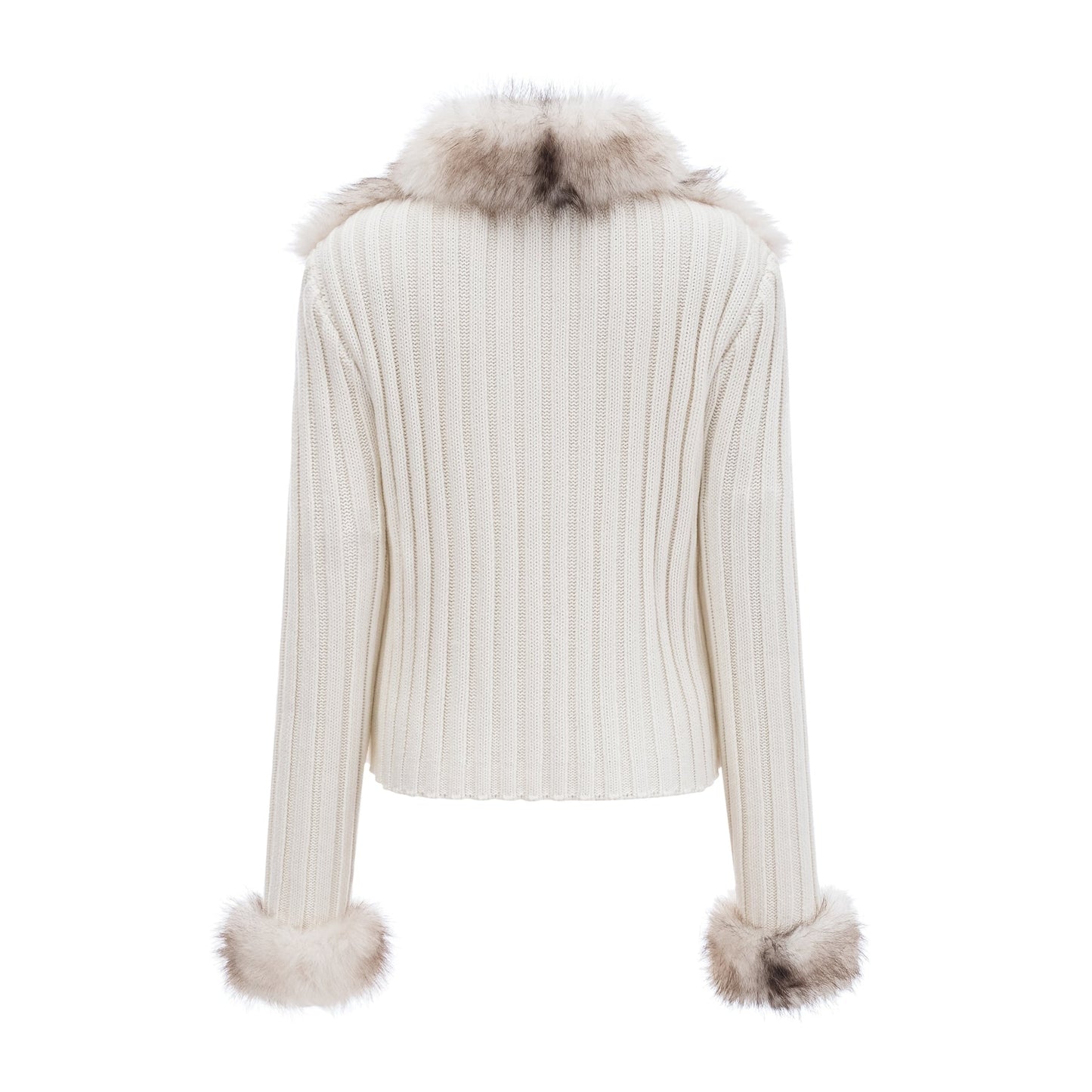 Woman wearing a cozy faux fur jacket with ribbed knit texture in a neutral color standing against a plain background