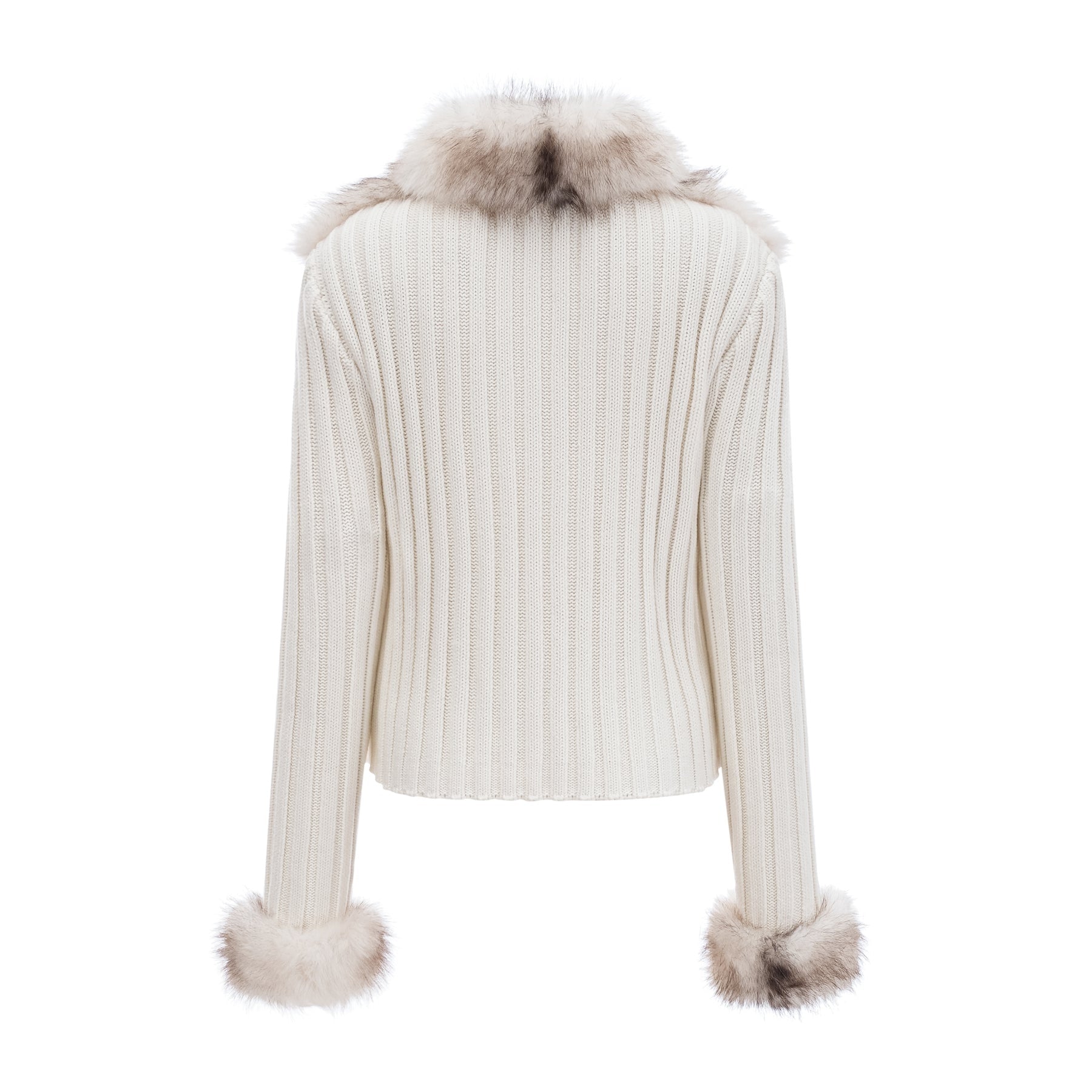 Woman wearing a cozy faux fur jacket with ribbed knit texture in a neutral color standing against a plain background