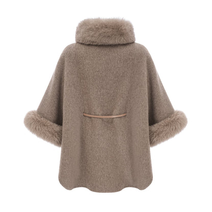 Woman wearing a brown wool cape coat with fur trim and belt cinched at the waist