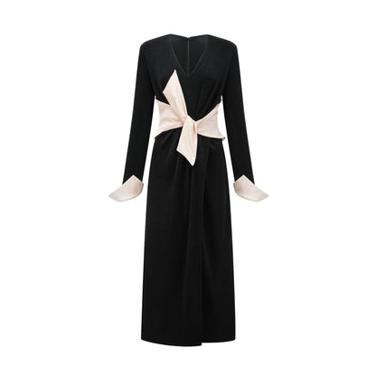 A long maxi dress with a vneck and contrasting colors featuring a prominent bowknot detail at the neckline