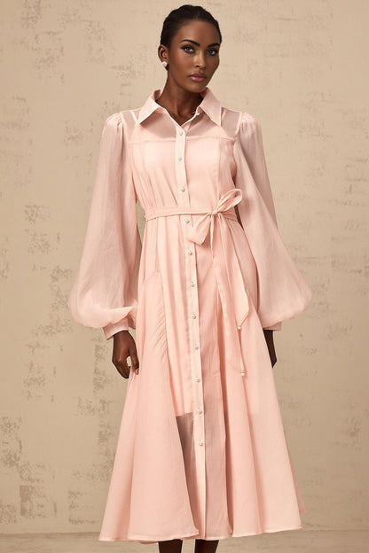 Woman wearing a pink midi length shirt dress with a tied waist detail