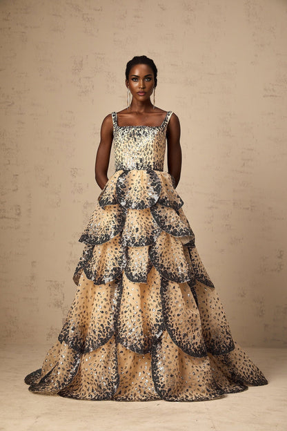 A long tiered maxi dress with shimmering sequined petals cascading down the tiers creating a floral effect