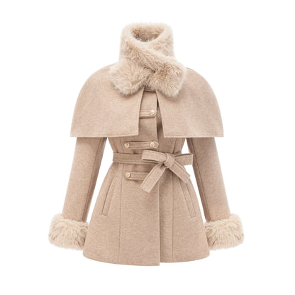 A woman wearing a black coat with a detachable faux fur cape around the shoulders the cape extends to the elbows and has a luxurious fluffy texture