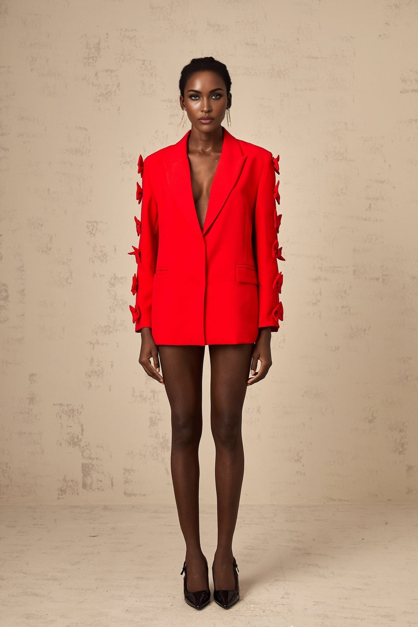 A red blazer with a bowknot detail and cutout design featuring a tailored fit and feminine silhouette