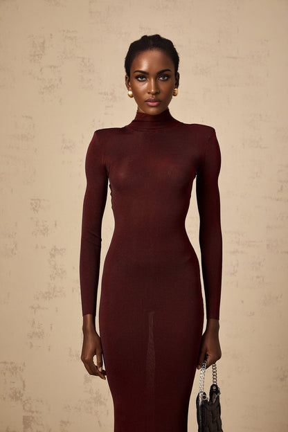 A woman wearing a red semisheer knitted midi dress with a fitted silhouette and long sleeves