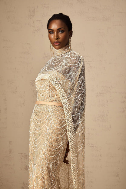 Woman wearing a champagne colored beaded gown with matching cape elegant formal attire for special occasions