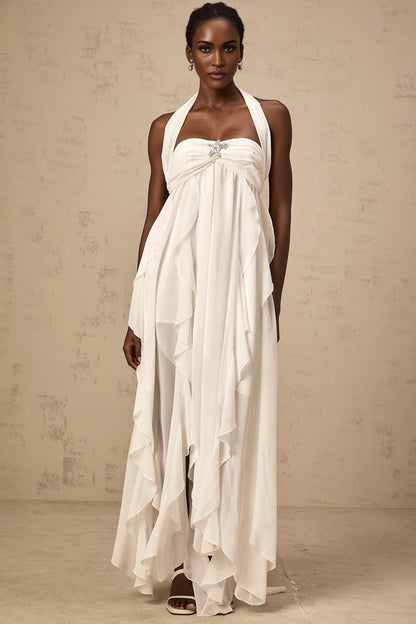 A long white chiffon maxi dress with ruffle details and a halter neckline worn by a model against a plain background