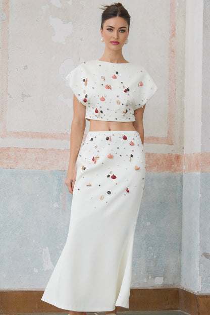 White matching set featuring a top and skirt adorned with shell embellishments named Delphine