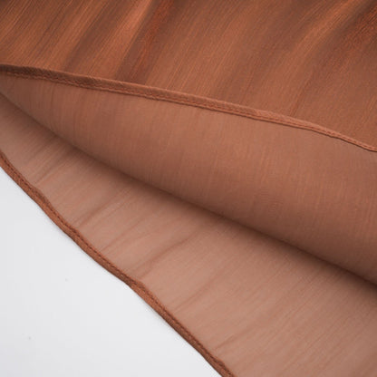 A long brown pleated satin maxi dress with a flowy silhouette