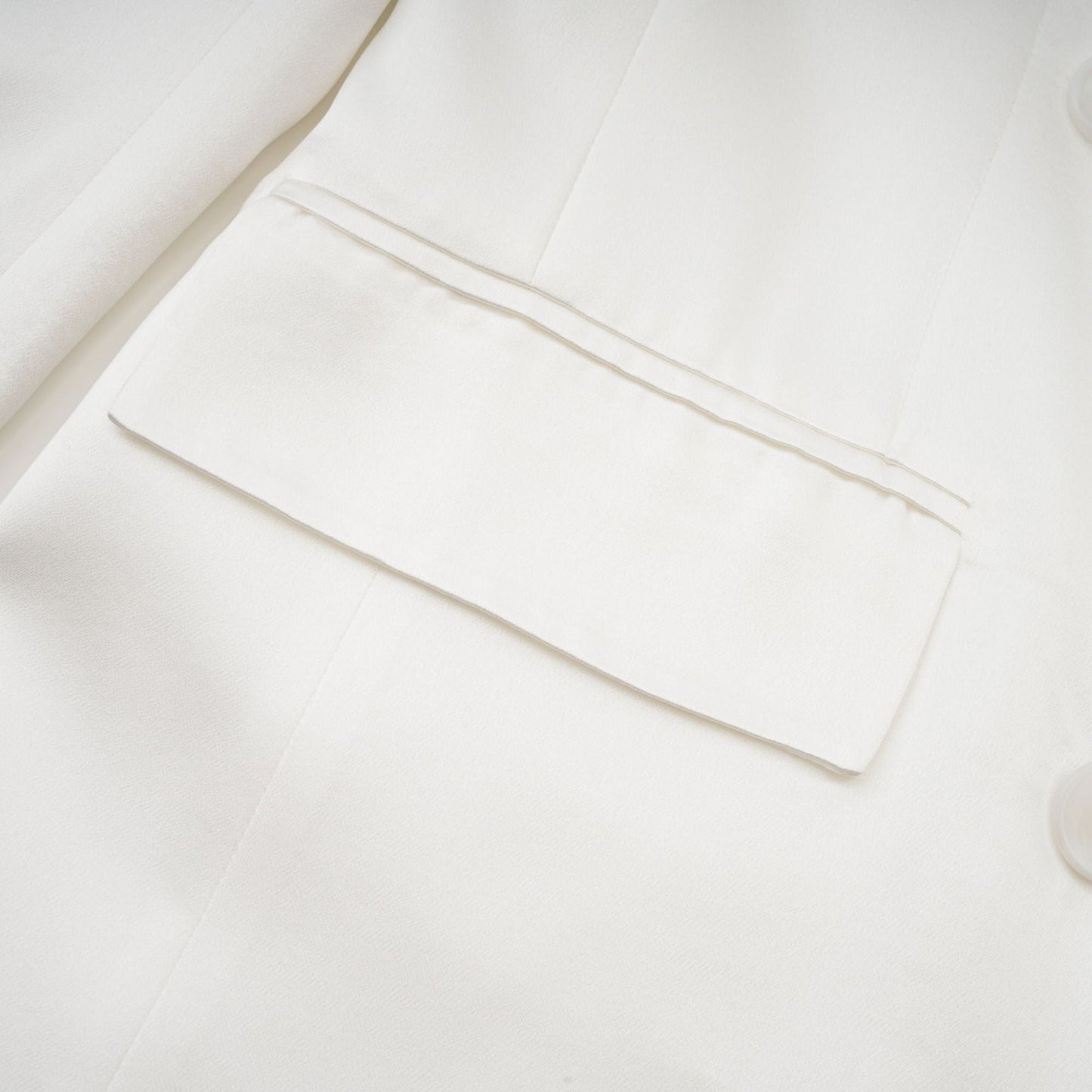 A white doublebreasted blazer named Sylvie on a plain background