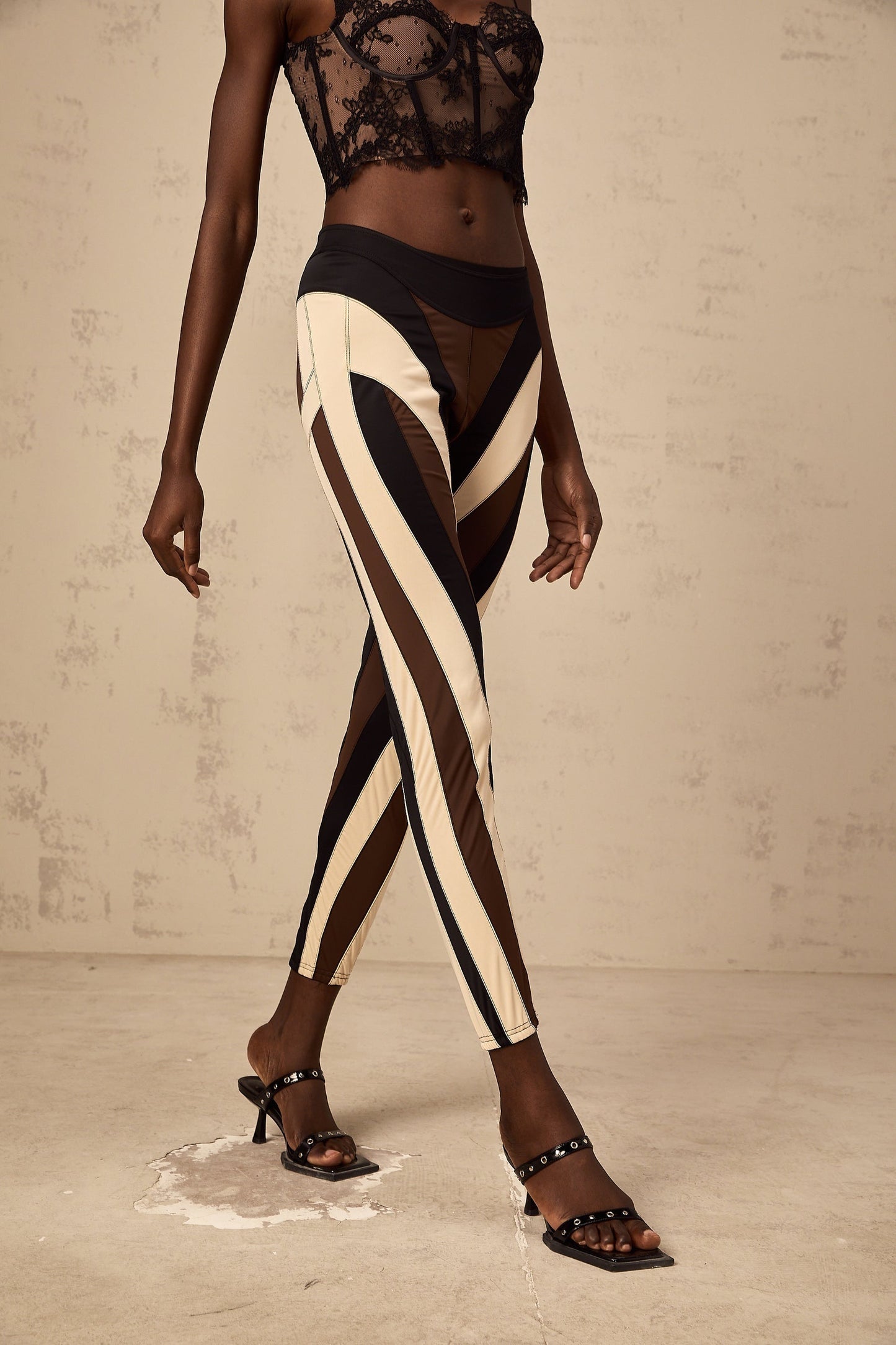 Woman wearing spiral color block panelled leggings in vibrant colors with a swirling pattern on the legs
