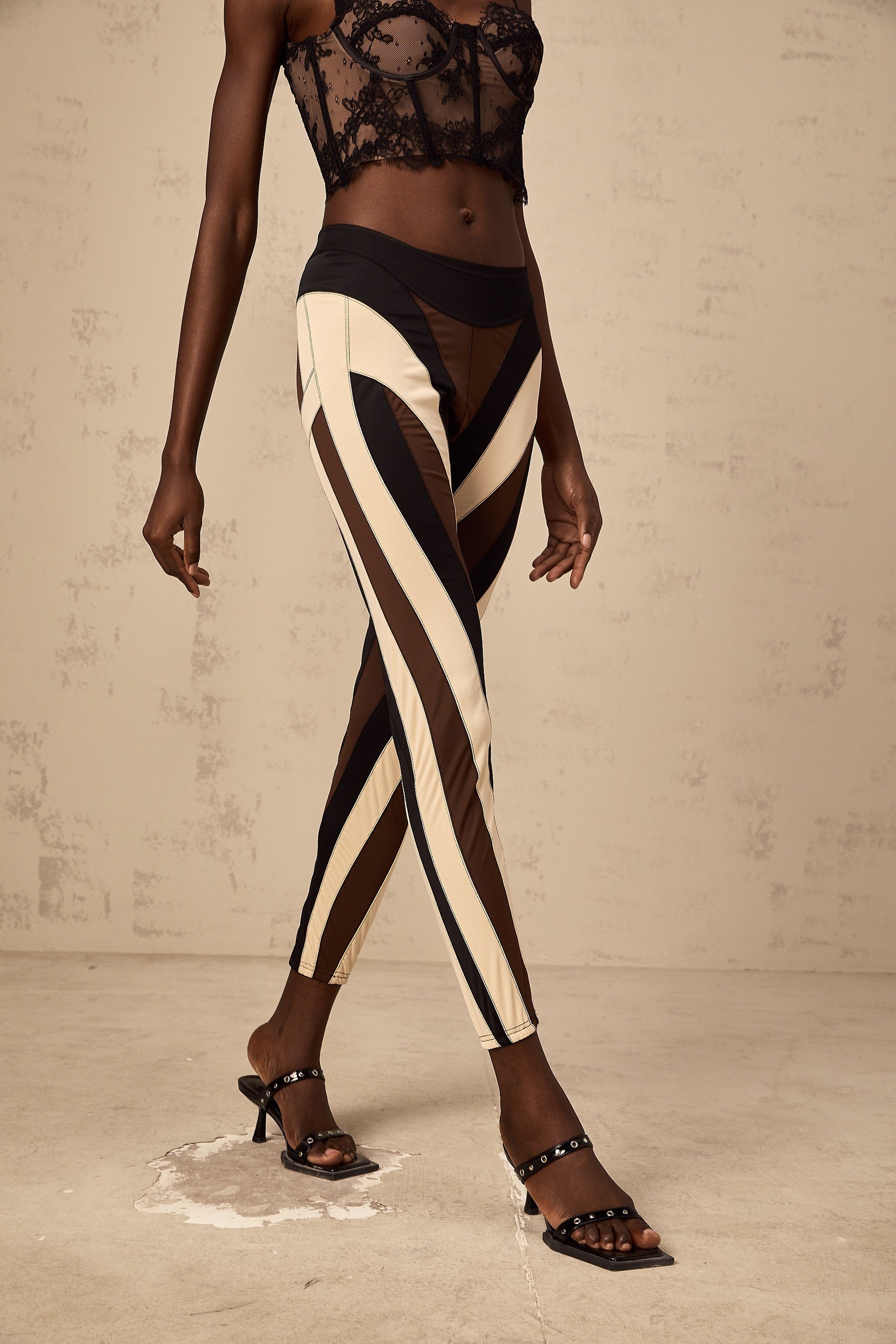 Woman wearing spiral color block panelled leggings in vibrant colors with a swirling pattern on the legs