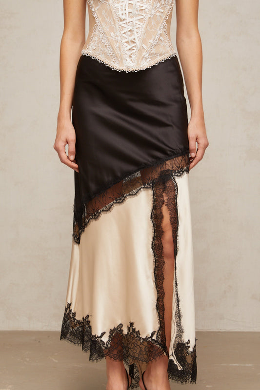 A sleek asymmetric satin skirt with delicate lace panel detailing named Raphaelle featuring a flowing silhouette and elegant design