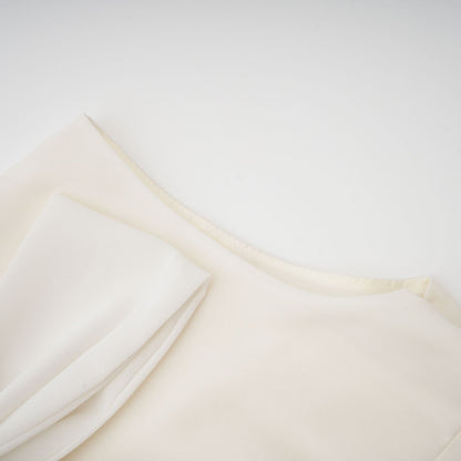 Woman wearing white pleated jacket and dress set with embellishments Blanche matching outfit elegant formal wear