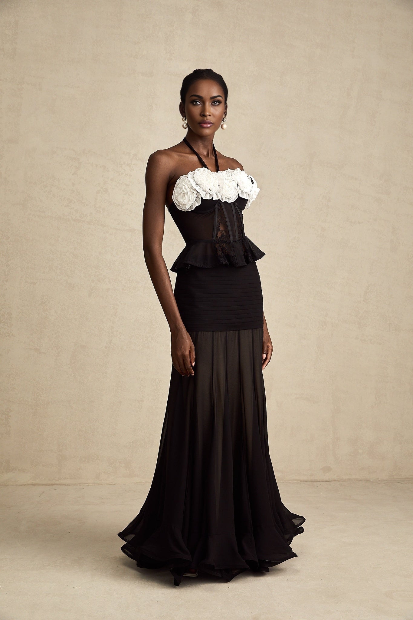 A black corset top with faux flower lace detailing and a structured bodice