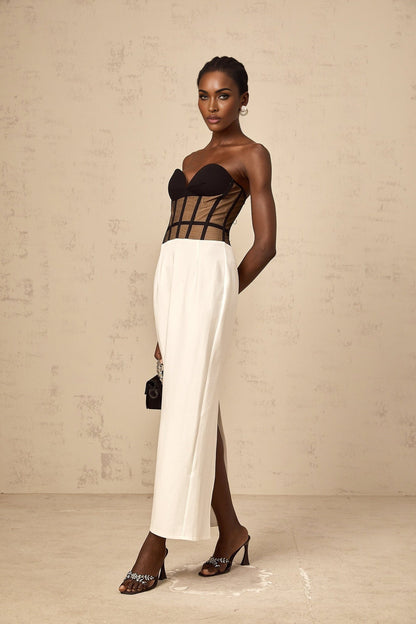 A long sheer maxi dress with a corset bodice featuring contrasting colors and a flowing skirt