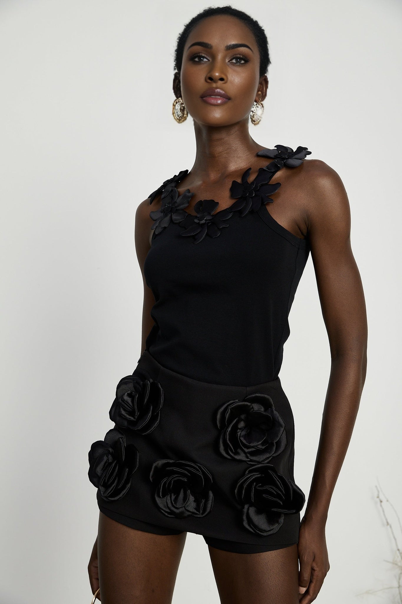 Black mini skirt with artificial flowers by Nalini
