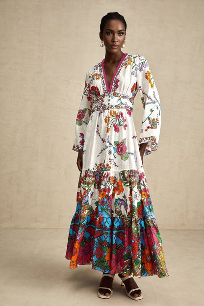 Woman wearing floral print midi dress with Vneck in soft colors standing against plain background