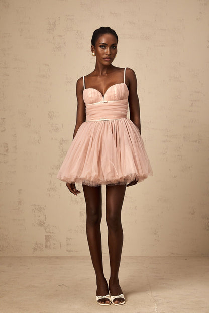 Woman wearing short white sleeveless dress with pleated tulle skirt