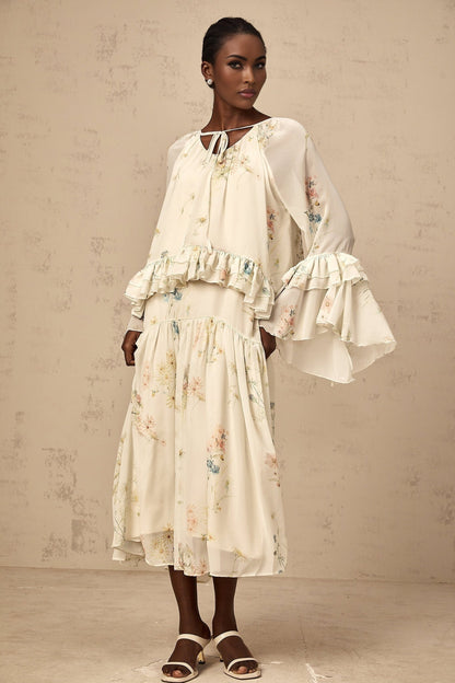 A matching set featuring a floral print blouse with ruffles and a coordinating dress in the same pattern and colors