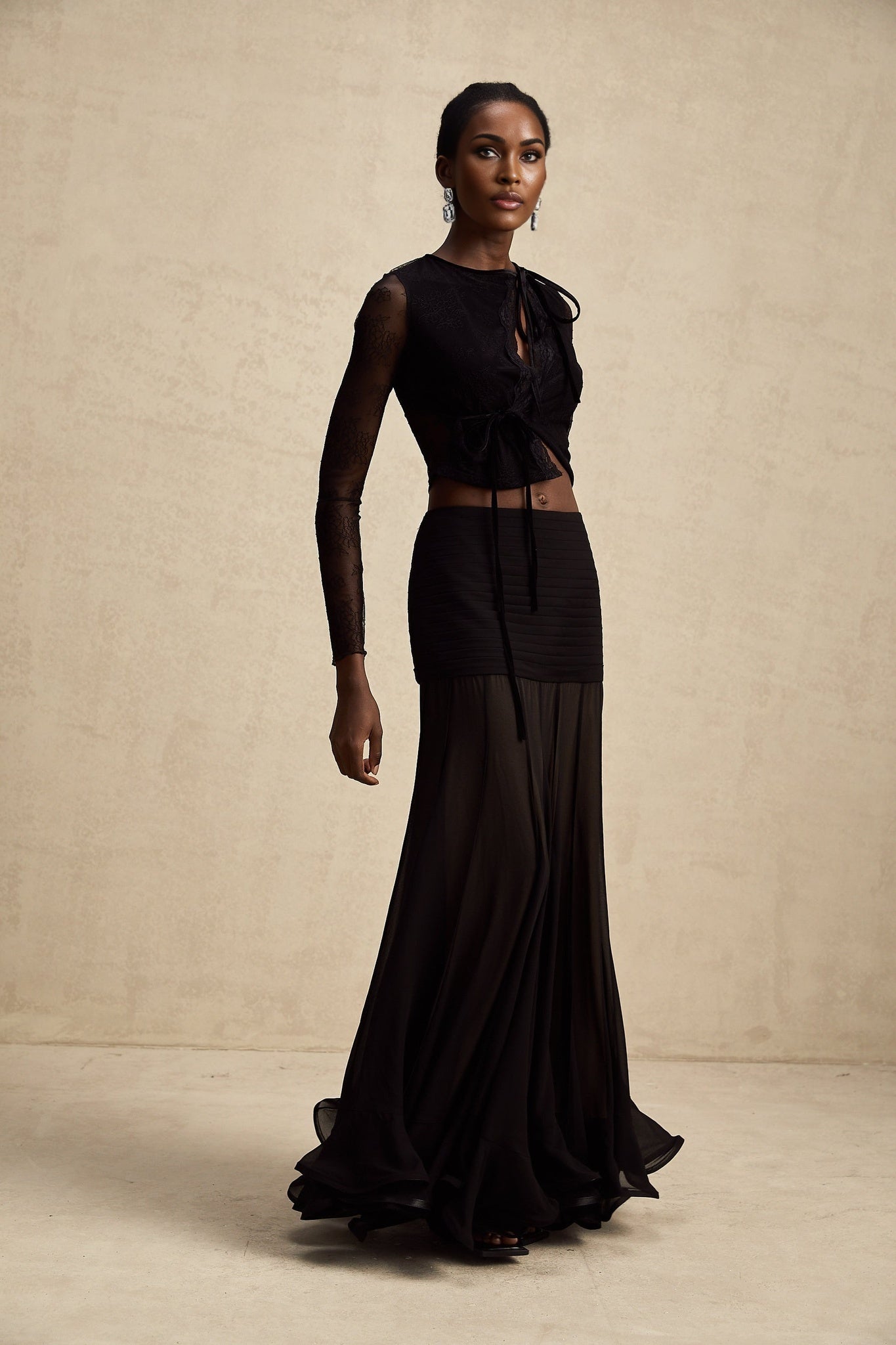 Woman wearing black cropped top with sheer lace details and thin straps