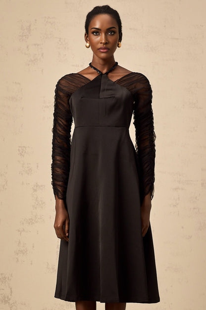 A black halterneck midi dress with panel detailing worn by a model against a plain background