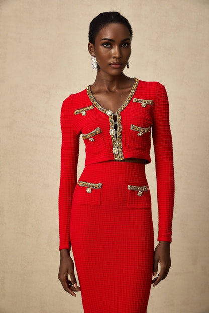 Woman wearing red knitted cardigan and matching skirt set with embellishments