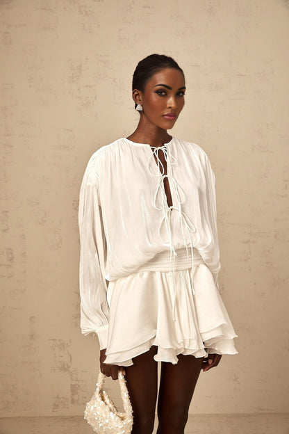 A short white pleated mini dress with a glittery shimmering effect named Mahault