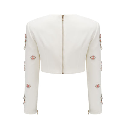 A white matching set consisting of a top and skirt adorned with crystal embellishments named Jeanne The outfit features a sleeveless top and a fitted skirt both decorated with sparkling crystals creating an elegant and sophisticated look