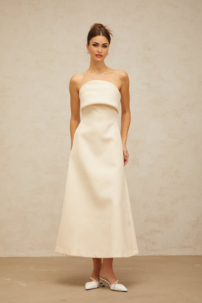 A white midi dress with a folded corset style bodice and a fitted silhouette named Raphaelle