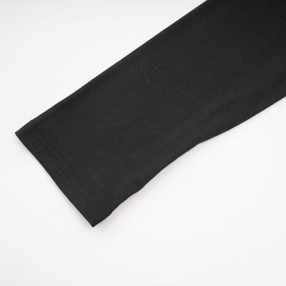 A black ruched top with long sleeves made of stretchy jersey fabric named Odette