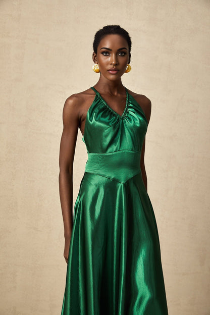 Woman wearing emerald green satin midi dress with open back detail