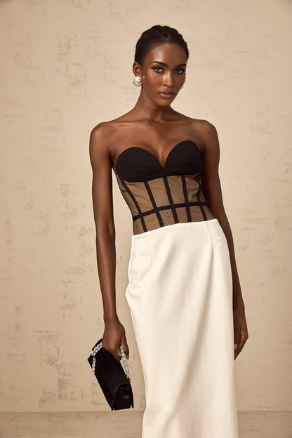 A long maxi dress with a sheer corset bodice featuring contrasting colors and a flowing skirt