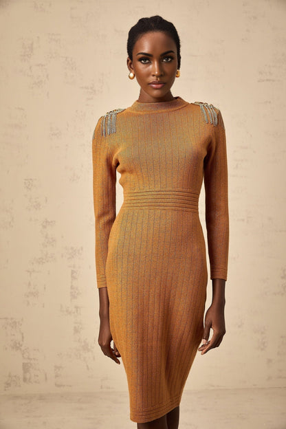 Woman wearing a formfitting ribbed knit midi dress with epaulet details on the shoulders in a neutral color