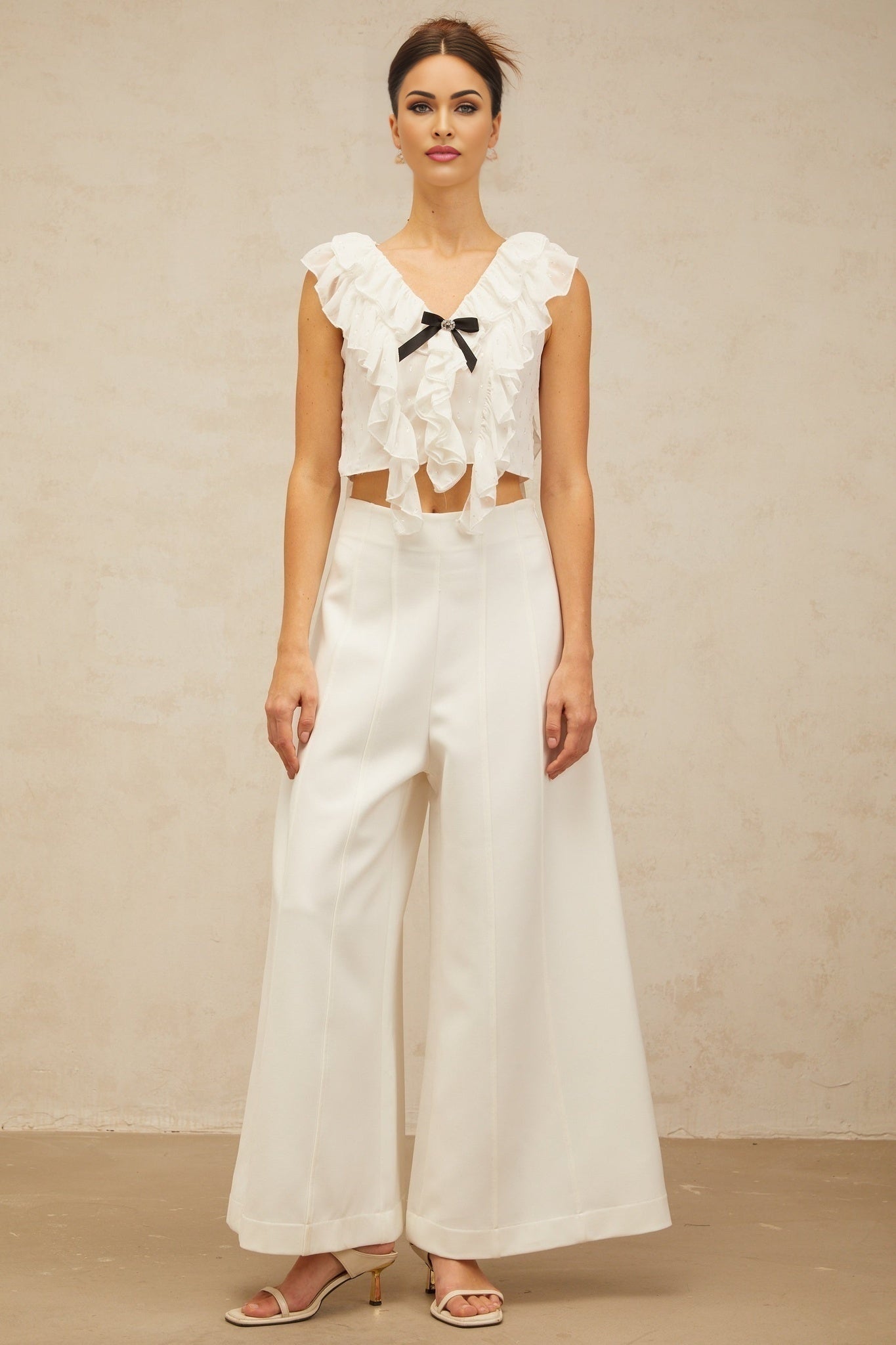 Woman wearing white cropped chiffon top with bowknot and ruffles