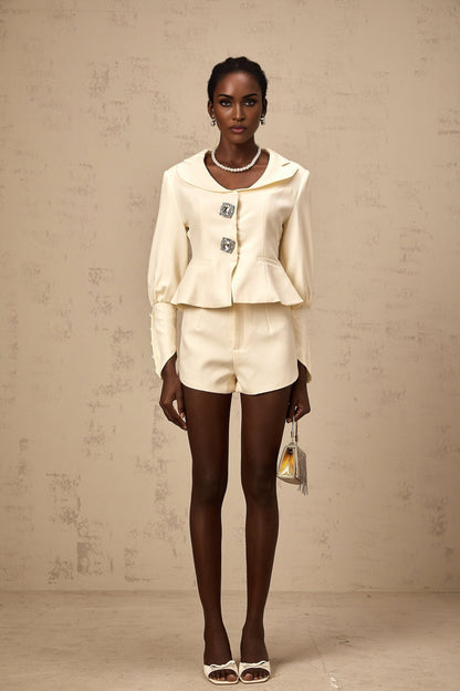 Woman wearing a matching jacket and shorts set embellished with crystal details in a stylish silhouette