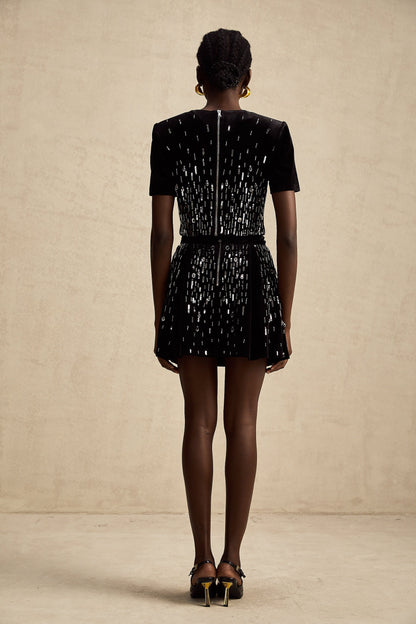 Woman wearing black velvet matching set consisting of embellished top and skirt named Isabeau