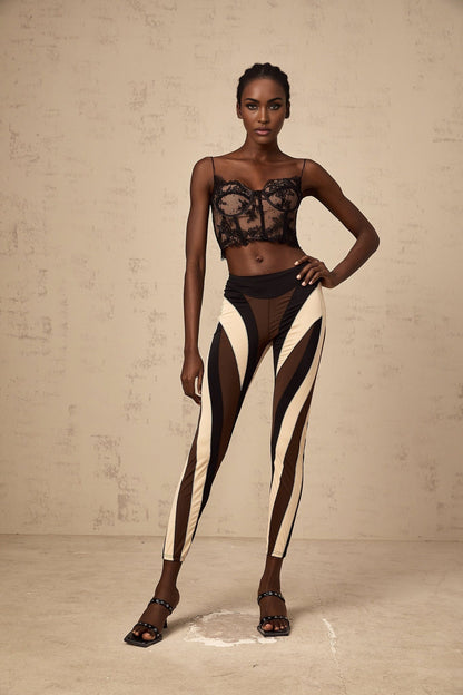 Woman wearing colorful spiral patterned leggings with color block panels in various bright hues