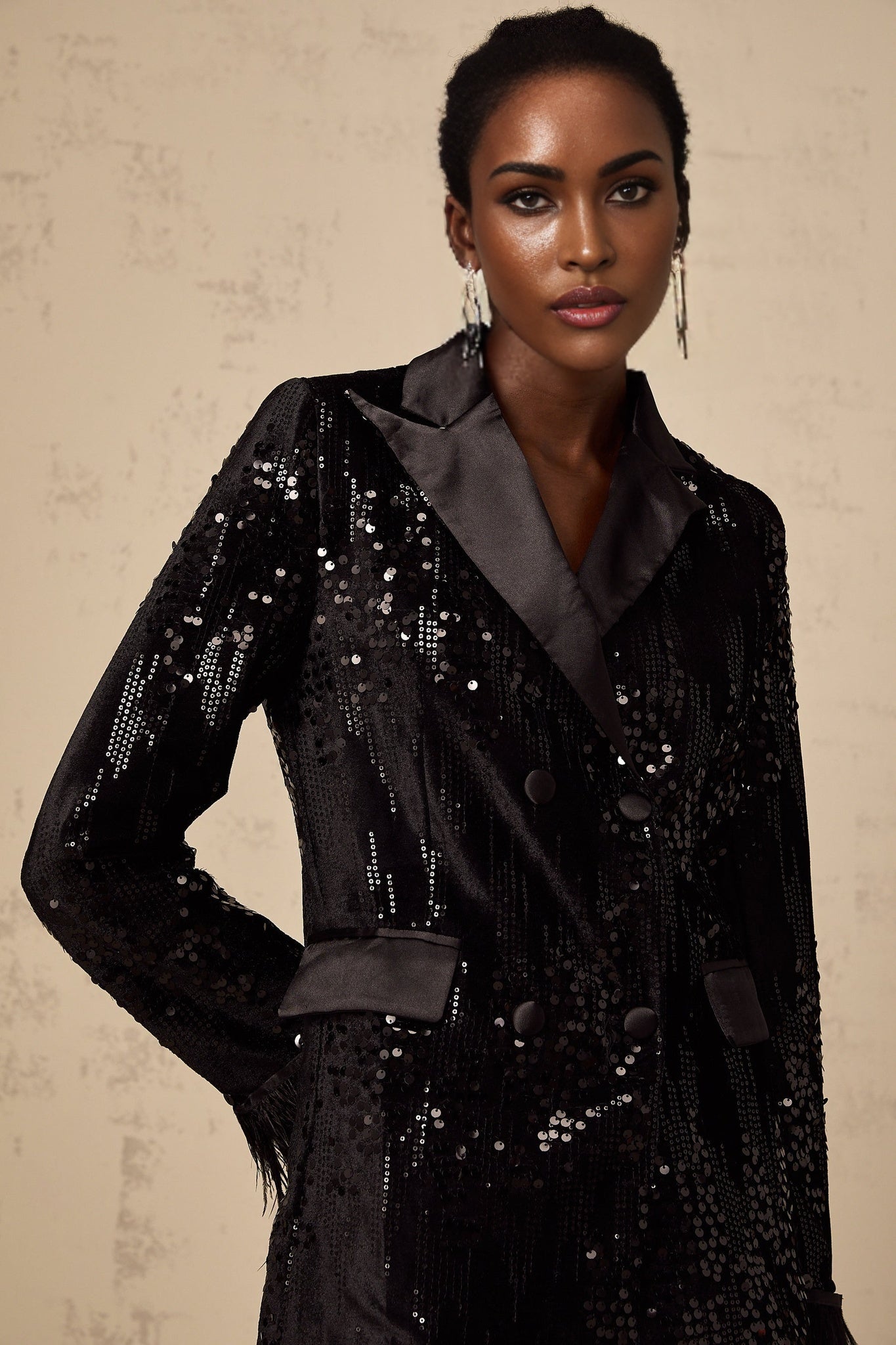 A black blazer with feather trim and sequin embellishments