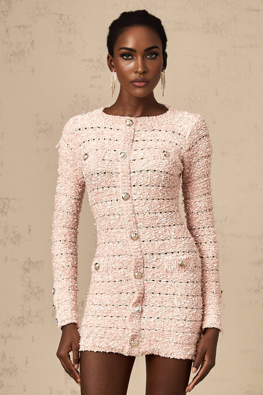 A pink fitted knit mini dress on a model showing the formfitting silhouette and short length