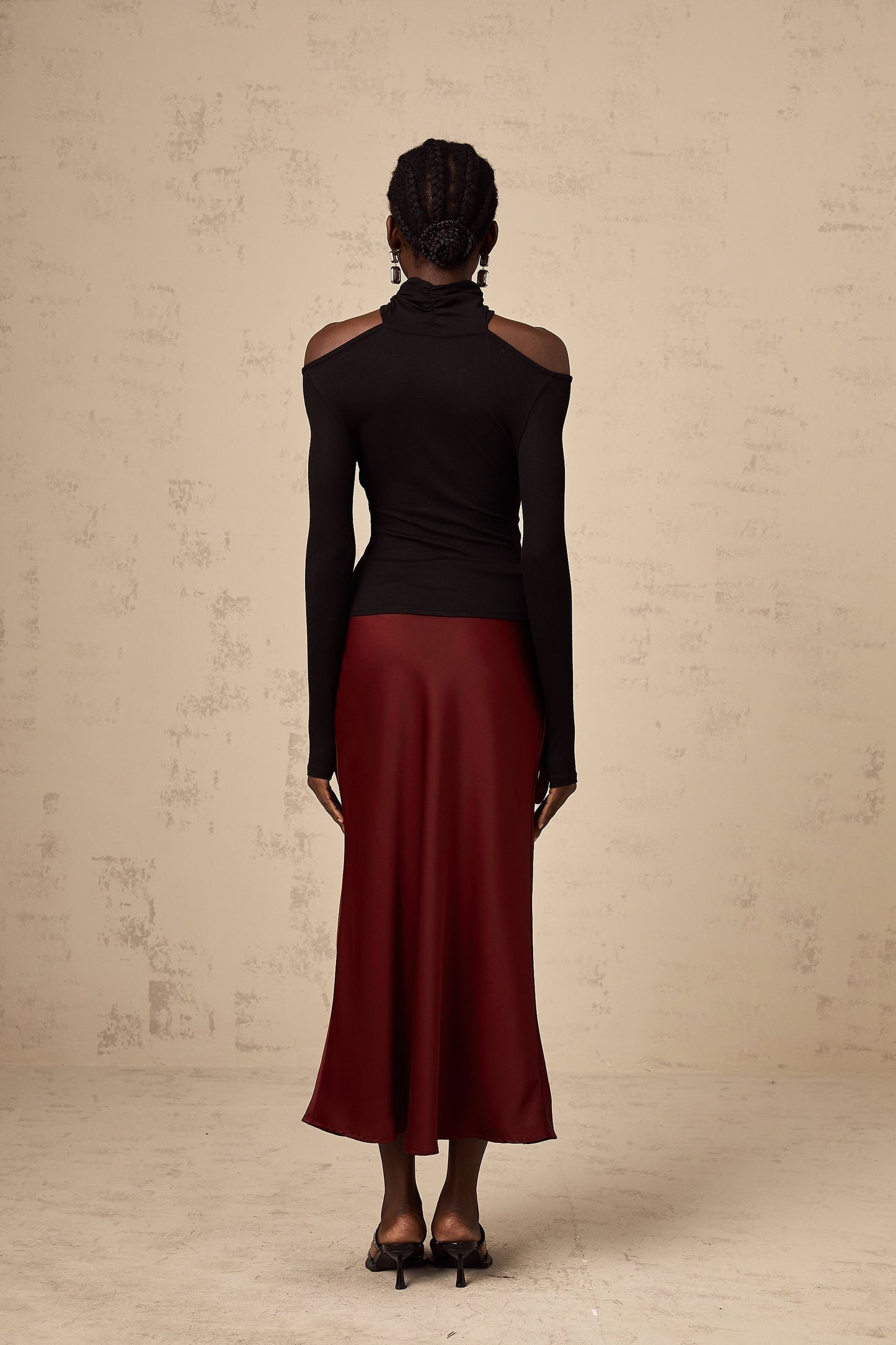 A black longsleeved top with ruched detailing made from stretchy jersey fabric